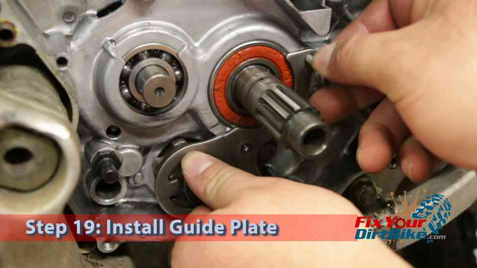 Hold the guide plate in place as you thread the retaining bolts.