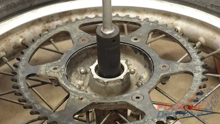 Step 9 & 10: Flip your wheel over and align your socket to the INNER bearing race, and tap until the brake side bearing falls out.