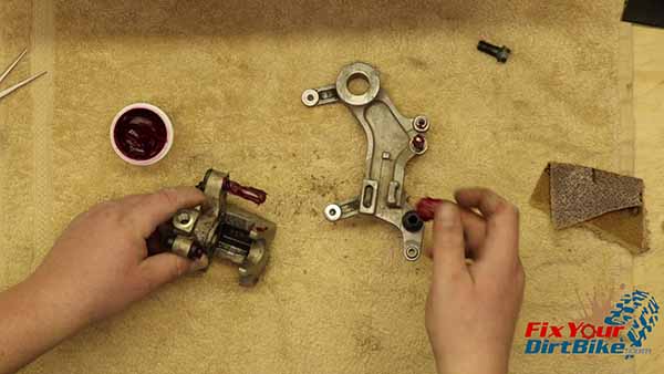 Add a layer of grease to the caliper sliders, and assemble the caliper and the mount.