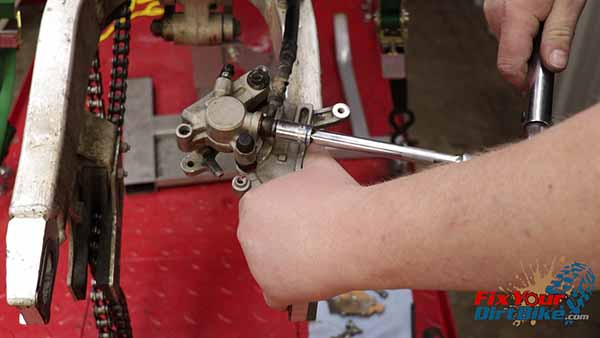 Hold the bracket to the swingarm, and torque the banjo bolt to 25-foot-pounds.