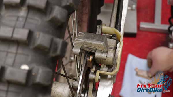 Start by removing the brake pad pin and brake pads while your caliper is still on your bike.