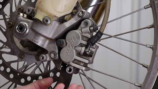 Remove the brake pads, but do not remove the caliper.
