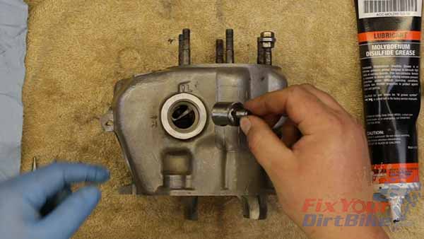  Lubricate the left Sub-Exhaust valve with 2-stroke oil. Align the valve with the valve shaft, and press it into the bore.
